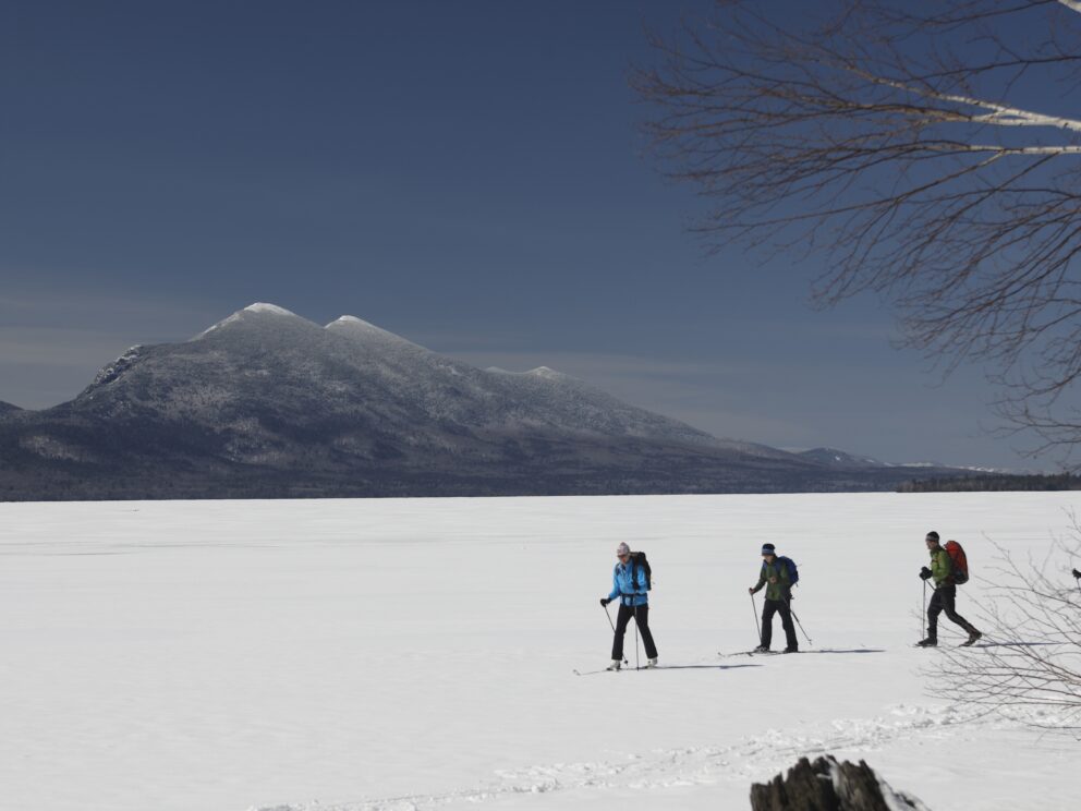 Skiing on Flagstaff Lake with mountains in the background.