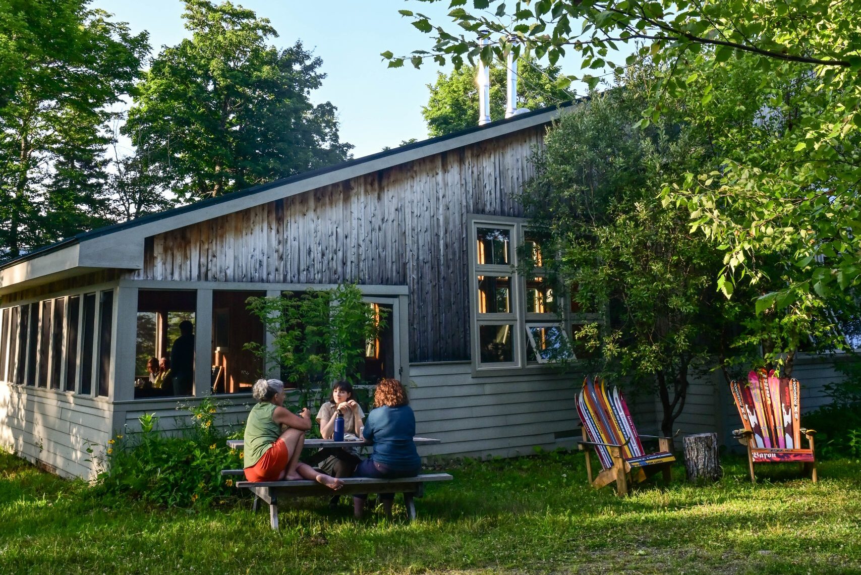 People sitting outside of Stratton Brook Hut