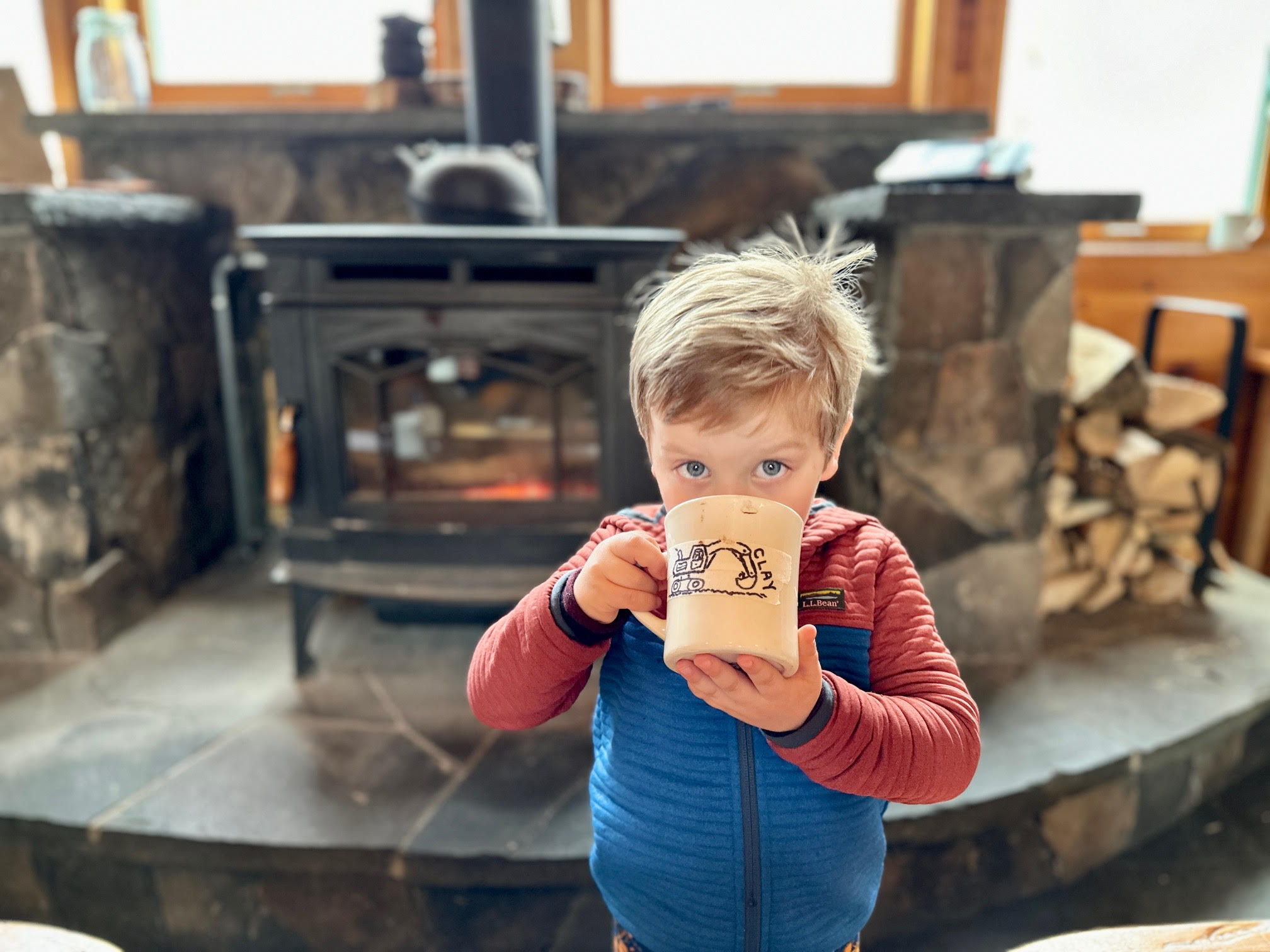 Young boy drinking hot cocoa at Flagstaff Lake Hut.