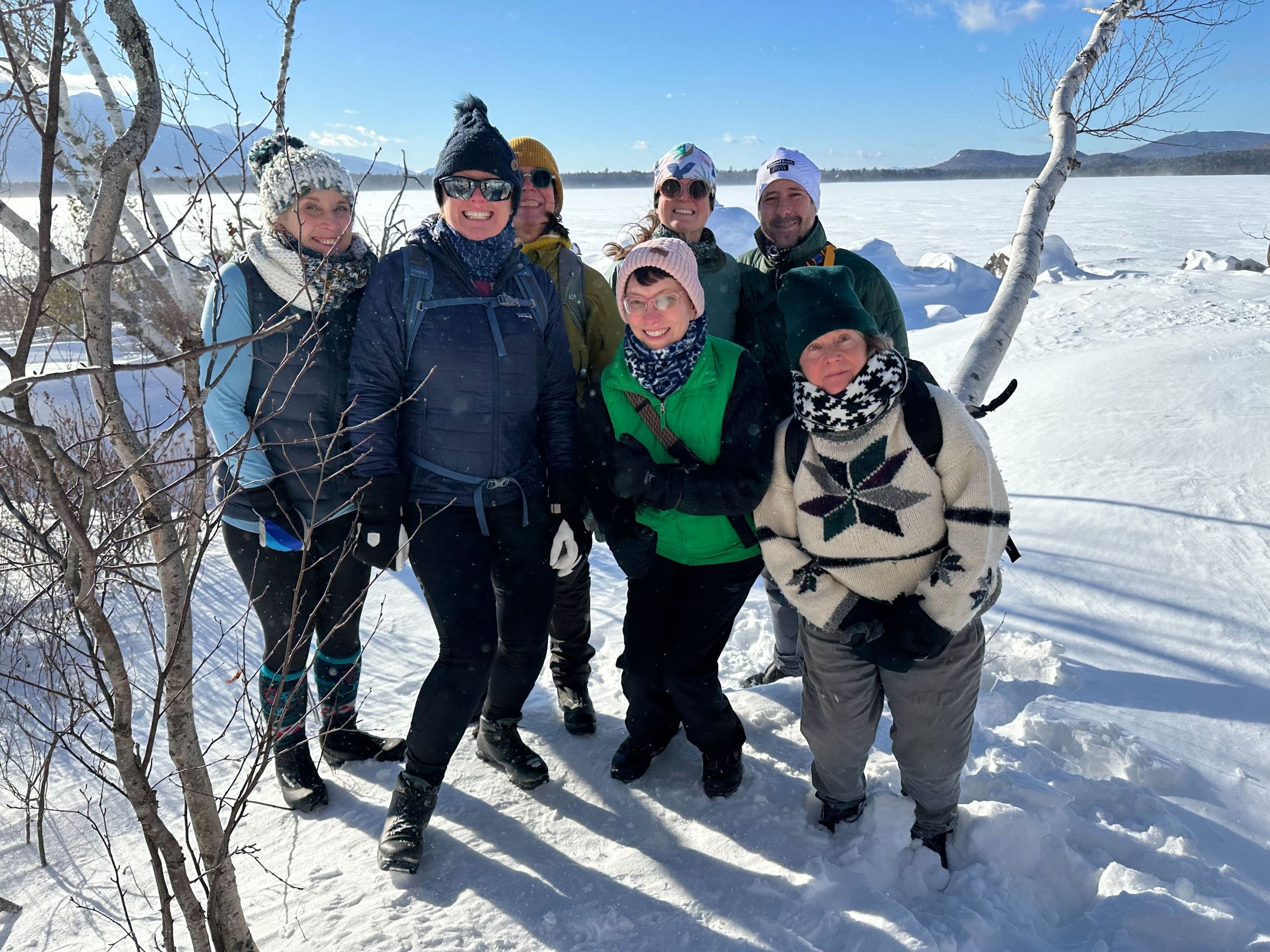 Group of guests on the shore of Flagstaff Lake in winter.