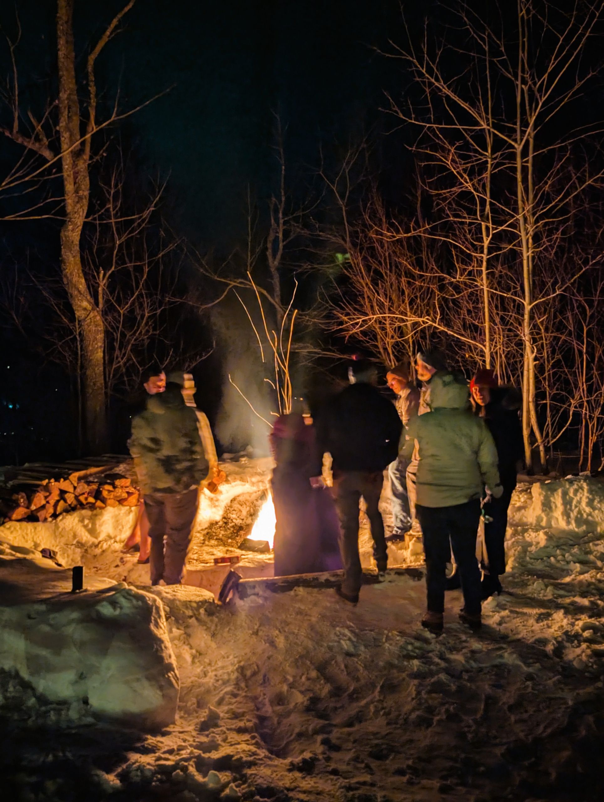 Guests gather around the outside firepit at Stratton Brook Hut.