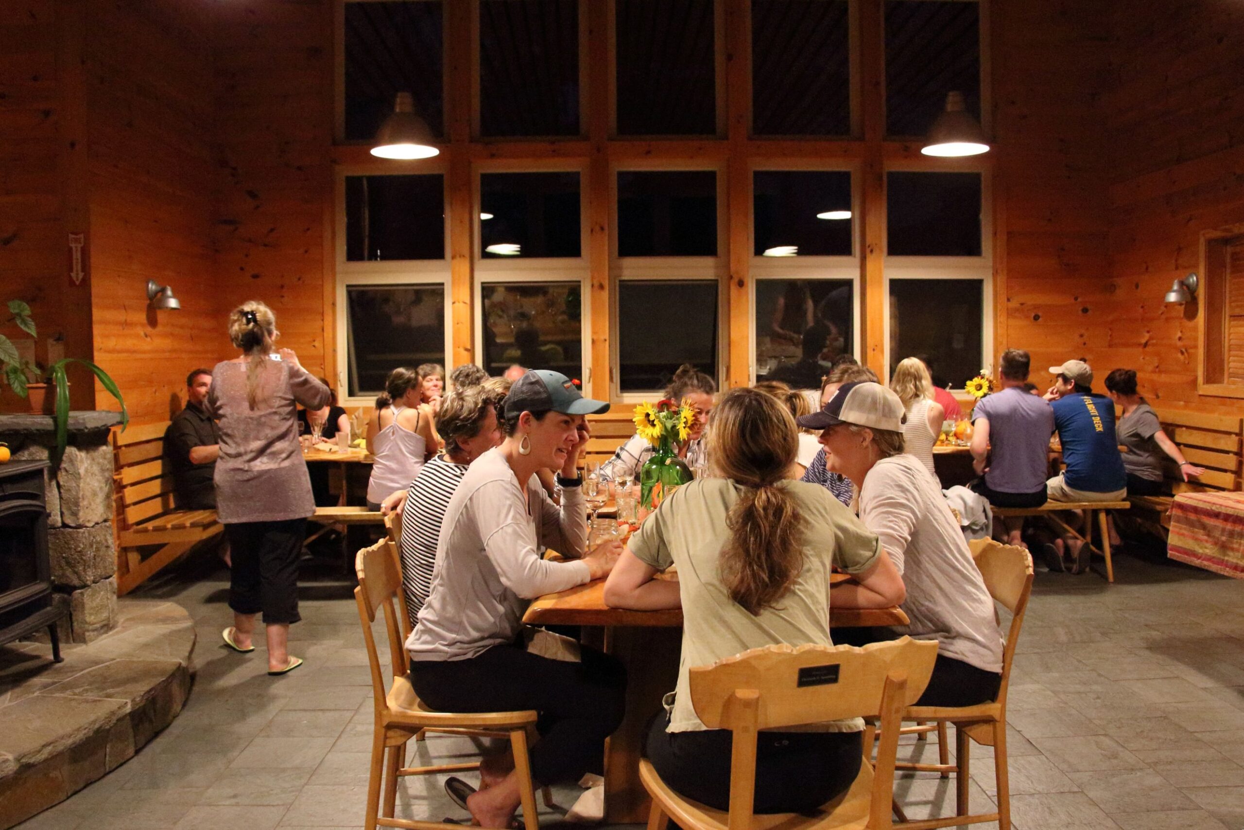 Guests eating indoors at an evening event at Stratton Brook Hut.