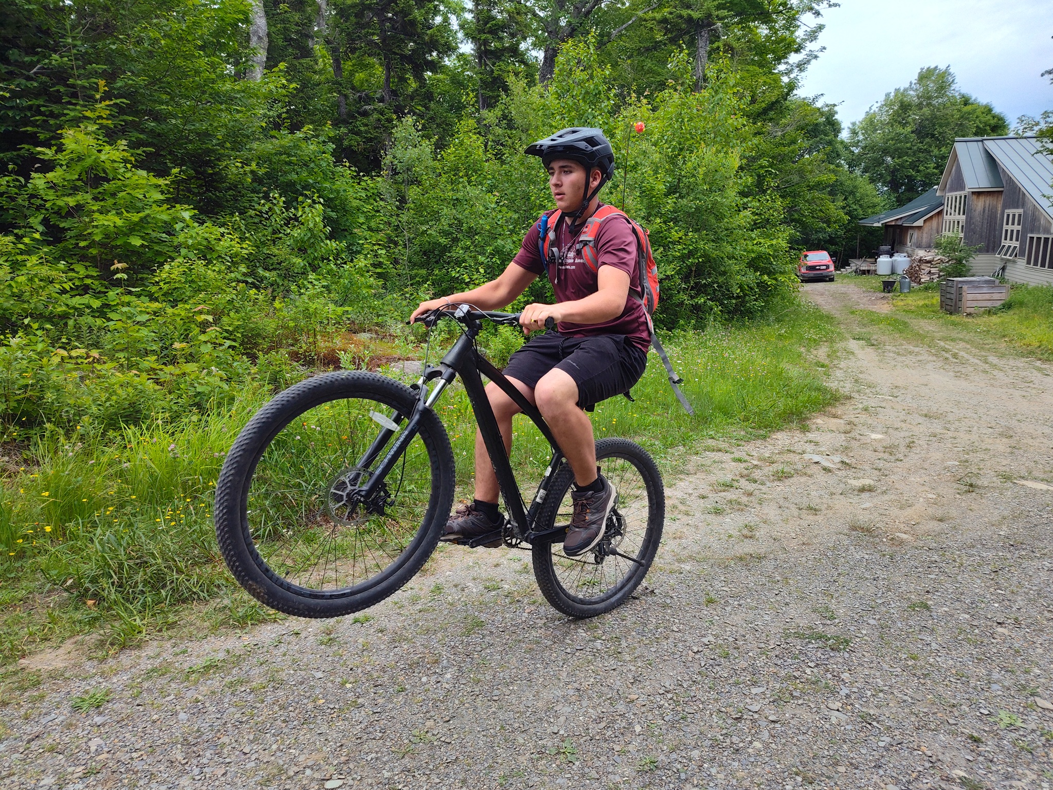 Popping a wheelie outside Stratton Brook Hut on a mountain bike.